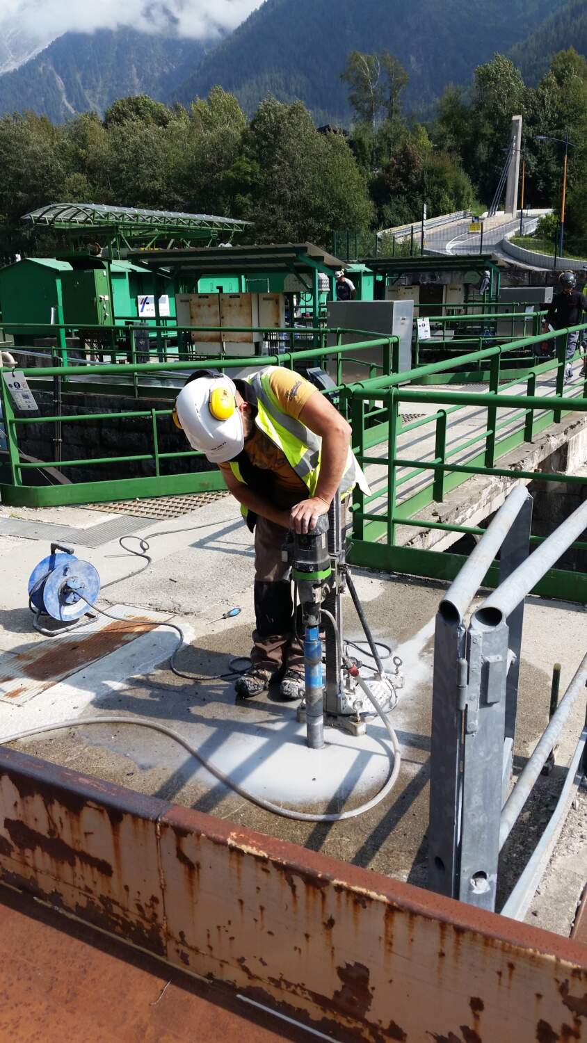 Photo d'une personne entrain de faire un trou dans du béton